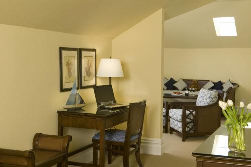 a hotel room with a desk and a bedroom at West Cliff Inn, A Four Sisters Inn in Santa Cruz