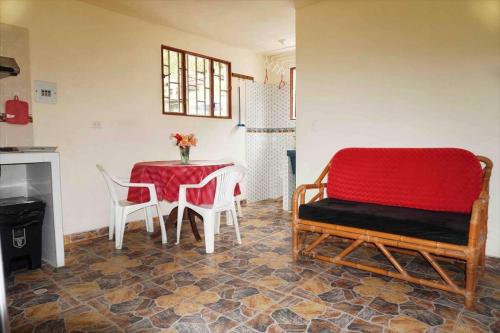 a living room with a table and chairs and a red couch at FINCA EL PROGRESO cabañas tipo apartamento in Anapoima