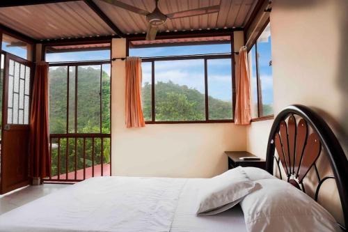 a bedroom with a bed and a large window at FINCA EL PROGRESO cabañas tipo apartamento in Anapoima