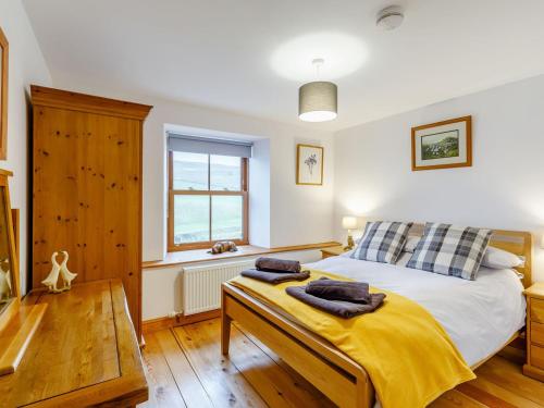 OuthgillにあるAisgill Farm Cottage - Uk31183のベッドルーム1室(ベッド1台、テーブル、タオル付)