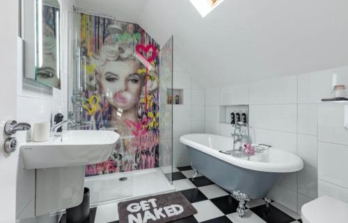 a bathroom with a painting of a woman on the wall at Mrs Butler’s Mews House in Brighton & Hove