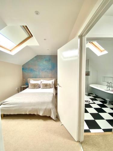 a bedroom with a bed and a bathroom with a tub at Mrs Butlers Stylish Mews House Central Brighton Great Prices in Brighton & Hove