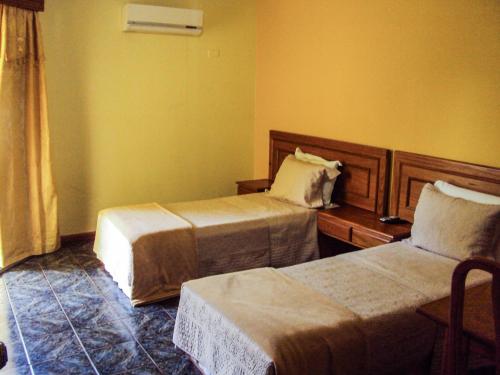 a hotel room with two beds and a table at Canzi Cataratas Hotel in Foz do Iguaçu