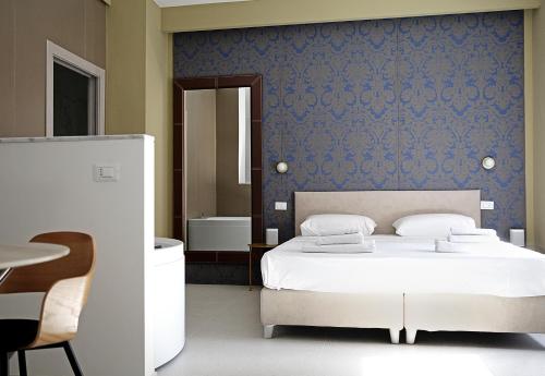 a bedroom with a white bed and a blue wall at Romantic Verona in Verona