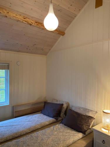 um quarto com uma cama e um candeeiro em Unstad cabin with seaview em Unnstad
