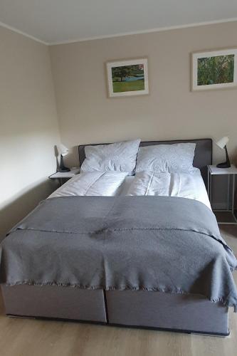 a large bed in a bedroom with two end tables at fewo-grundi in Extertal