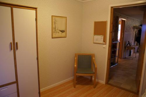 a room with a chair and a mirror and a door at Mellangården in Västerbykil