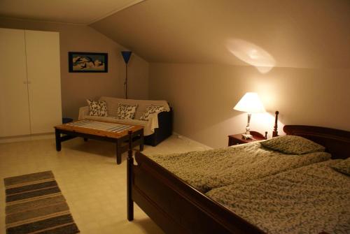 a bedroom with a bed and a couch and a table at Mellangården in Västerbykil