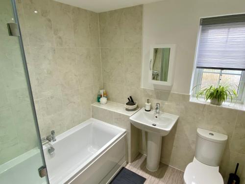 a bathroom with a tub and a toilet and a sink at Holly House - Executive Rural Home with Jacuzzi in Penistone