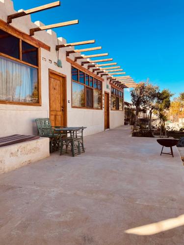 a patio with a table and benches next to a building at Moon_Valley_Siwa in Siwa