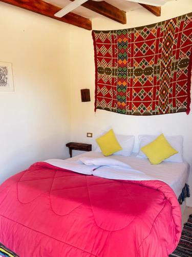 a bedroom with a red blanket on a bed at Moon_Valley_Siwa in Siwa