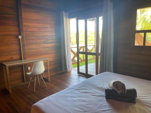 a bedroom with a bed and a desk and a chair at Pousada Wind Rose in Itarema