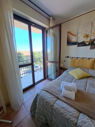 a bedroom with a bed and a large window at Apartament Thermae in Bagni San Filippo