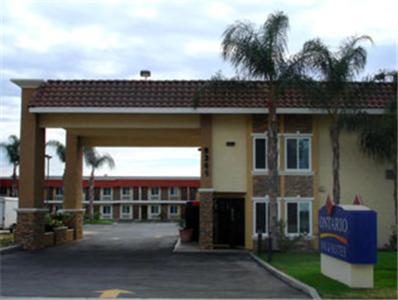 a large building with a palm tree in front of it at Ontario Inn & Suites in Montclair