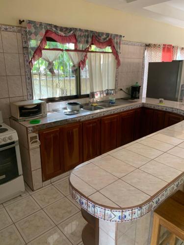 a kitchen with wooden cabinets and a counter top at Beach house Matapalo Santa Cruz in Matapalo