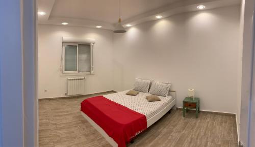 布米爾達斯的住宿－Le Rocher，一间卧室配有一张带红色毯子的床和窗户。