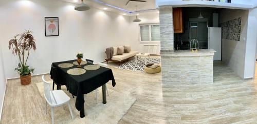 a living room with a table and a couch and a kitchen at Le Rocher in Boumerdes