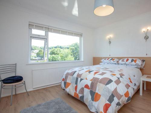 um quarto com uma cama grande e uma janela em Bethany em Brixham