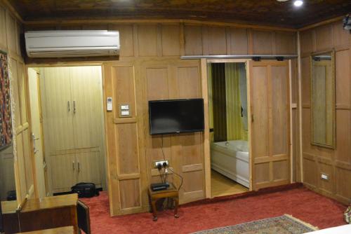 a room with wooden cabinets and a flat screen tv at New York Houseboat in Srinagar