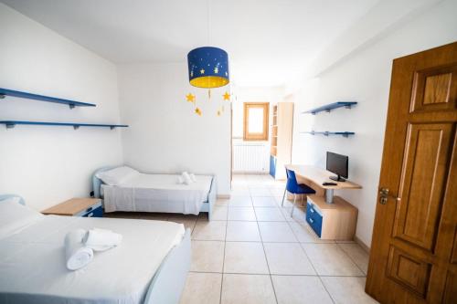 Zimmer mit 2 Betten und einem Schreibtisch mit einem Computer in der Unterkunft Villa Vespucci in Torricella