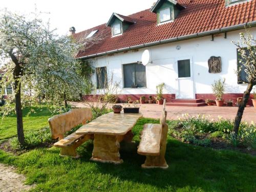 una mesa de picnic de madera en el patio de una casa en Hajdu Lovasudvar Hortobágy, en Hortobágy