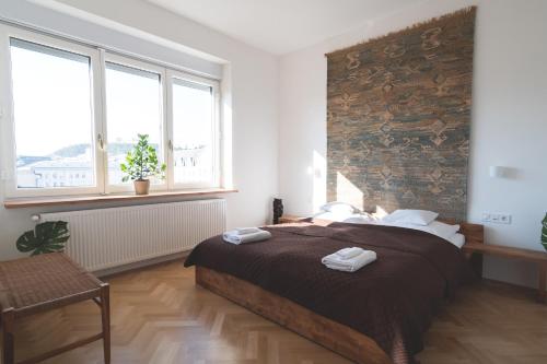 een slaapkamer met een groot bed en 2 handdoeken bij The Grand Budapest Apartment in Boedapest
