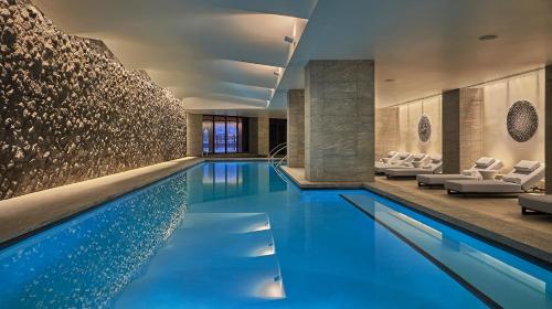 a pool in a hotel with white chairs and a lobby at Montage Big Sky in Big Sky