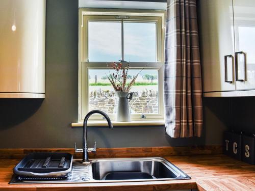 a kitchen with a sink and a window at Hare Cottage in Westgate