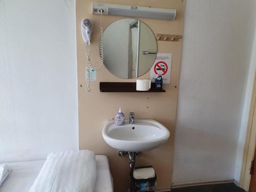 a bathroom with a sink and a mirror and a tub at Märkischer Hof Hotel in Berlin