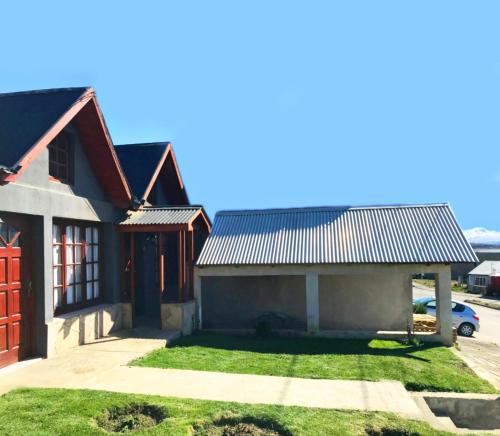 a house with a red door and a garage at La hogareña in El Calafate