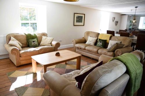 a living room with couches and a coffee table at The Stables in Pitlochry