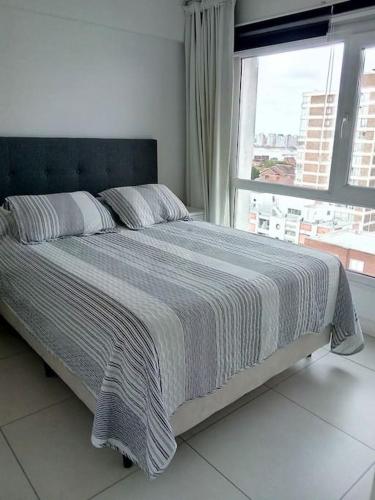a bedroom with a large bed with a window at Lux Tower. Departamento 3 ambientes. Pleno centro in Punta del Este