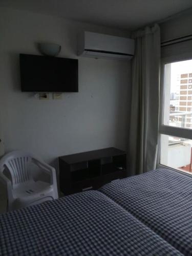a bedroom with a bed and a chair and a window at Lux Tower. Departamento 3 ambientes. Pleno centro in Punta del Este
