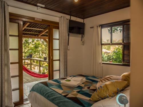 1 dormitorio con 1 cama y puerta corredera de cristal en Morada da Sereia, en Ilha do Mel