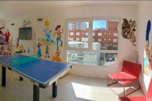 a room with a ping pong table and a red chair at Lux Tower. Departamento 3 ambientes. Pleno centro in Punta del Este