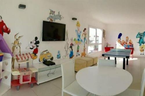 a living room with a tv on a wall with cartoon characters at Lux Tower. Departamento 3 ambientes. Pleno centro in Punta del Este