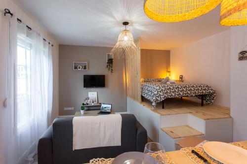 une petite pièce avec un lit et une table dans l'établissement l'Estrade d'Amiens - Studio Atypique et de Standing avec Parking, à Amiens