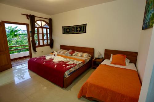 1 dormitorio con 2 camas y ventana en The Galapagos Pearl B&B, en Puerto Ayora