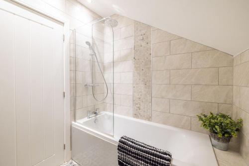 a bathroom with a white tub and a shower at Cleethorpes Holiday Home SLEEPS 6 in Cleethorpes
