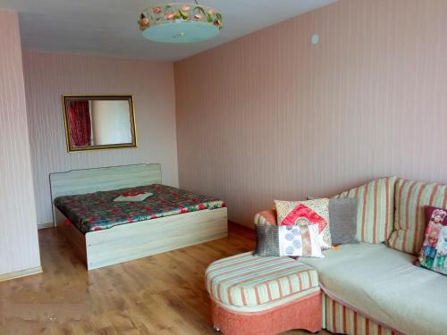 a room with a couch and a bed in it at BuTaS TaUrAgEje in Tauragė