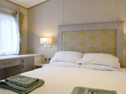 um quarto com uma cama branca e uma cabeceira. em Tranquil Lodge - Uk35277 em Brigham