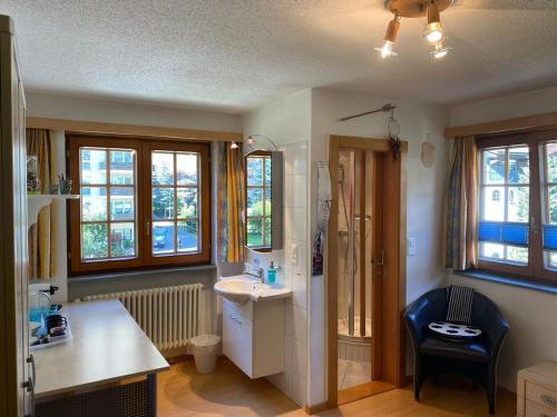 łazienka z umywalką, toaletą i oknami w obiekcie Chalet Medi w mieście Zermatt