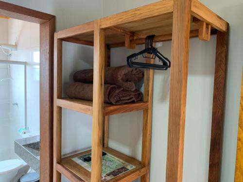 a wooden book shelf with towels in a bathroom at Flat dos Bandeirantes in Tiradentes