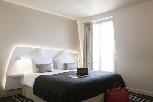 a hotel room with a large bed and a window at Mercure Paris Levallois in Levallois-Perret