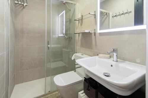 een badkamer met een wastafel, een toilet en een douche bij Una casita en el Mentidero in Cádiz