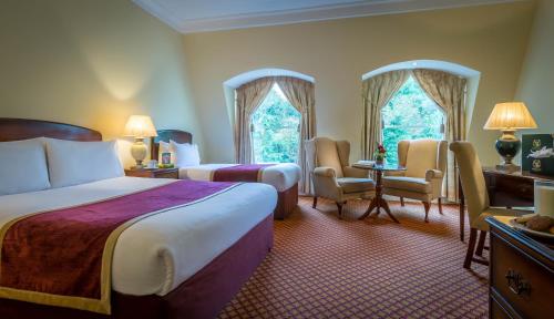 Habitación de hotel con 2 camas, mesa y sillas en The Glenview Hotel & Leisure Club en Newtown Mount Kennedy
