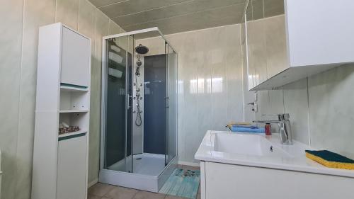 a white bathroom with a shower and a sink at Update Location in Lanester