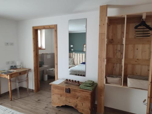 Habitación con espejo y mesa de madera. en Storie di bosco, en Villa Lagarina