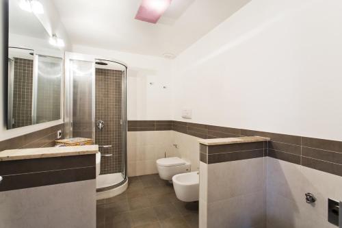 a bathroom with a toilet and a shower and a sink at Quattro canti luxury apartment in Palermo