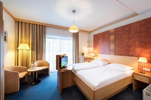 a hotel room with a bed and a tv at Parkhotel zur Klause in Bad Hall